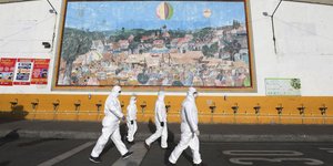 Άνδρες με στολές και μάσκες προστασίας από τη μετάδοση του κορωνοϊού