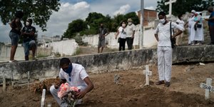Ανδρας αφήνει λουλούδι σε τάφο στην Βραζιλία