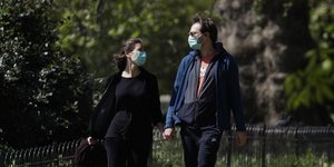 Ζευγάρι κάνει βόλτα σε πάρκο του Λονδίνου, φορώντας μάσκες για τον κορωνοϊό