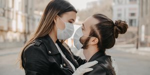 αγκαλιασμένο ζευγάρι με μάσκες και γάντια
