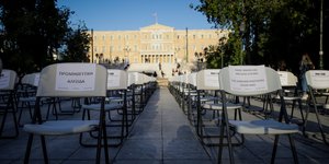 Παραταγμένες άδειες καρέκλες της ΠΟΕΣΕ στο Σύνταγμα, με φόντο το κτίριο της Βουλής