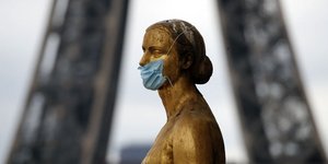 Άγαλμα με μάσκα προστασίας από τον κορωνοϊό με φόντο τον Πύργο του Άιφελ