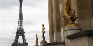 Αγάλματα με μάσκες προστασίας από τον κορωνοϊό, με φόντο τον Πύργο του Άιφελ στο Παρίσι