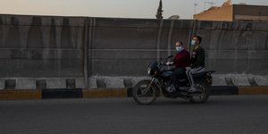 Αντρες με μάσκα πάνω σε μηχανή σε δρόμο της Αιγύπτου