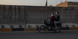 Ανδρες σε μηχανή στην Αίγυπτο φορώντας μάσκα για τον κορωνοϊό