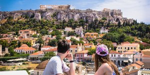 Airbnb: Ενα ζευγάρι τουριστών τρώει σε εστιατόριο με θέα την Πλάκα και την Ακρόπολη