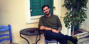 Ο Ακης Πετρετζίκης καθιστός σε καρέκλα