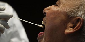 Άνδρας υποβάλλεται σε τεστ για τον κορωνοϊό με τη χρήση μπατονέτας