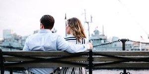 Ανδρας αγκαλιάζει γυναίκα σε παγκάκι