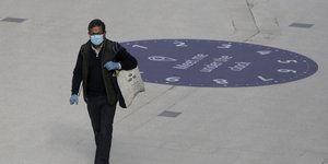 Άνδρας σε σταθμό του μετρό στο Λονδίνο με μάσκα προστασίας από τη μετάδοση του κορωνοϊού