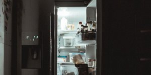 Ανοιχτό ψυγείο μέσα σε σκοτεινή κουζίνα