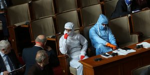 Άνδρες με στολές και μάσκες προστασίας από τον κορωνοϊό στο κοινοβούλιο της Βουλγαρίας