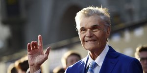 Ο Φρεντ Γουίλαρντ με μπλε κοστούμι και γαλάζια γραβάτα