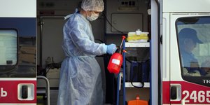 γιατρος ψεκάζει ασθενοφόρο 