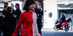 Γυναίκα με μαύρο καρέ φοράει κόκκινο μπεζ πουκάμισο