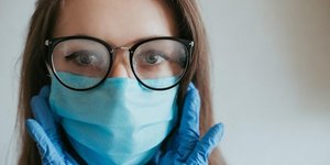 Γυναίκα φοράει γυαλιά και μάσκα στο πρόσωπο
