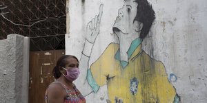 γυναίκα με μάσκα στη Βραζιλία μπροστά από γκράφιτι
