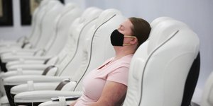 Γυναίκα αναπαύεται σε κάθισμα σε σπα φορώντας μάσκα