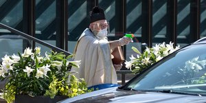 Ιερέας ψεκάζει αγιασμό με νεροπίστολο