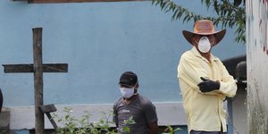Ανδρας με καπέλο και μάσκα σε νεκροταφείο στον Ισημερινό
