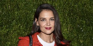 Η Κέιτι Χολμς με κόκκινο σακάκι και λευκή μπλούζα