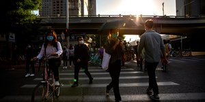 Κινέζοι περπατούν στον δρόμο με μάσκες για τον κορωνοϊό