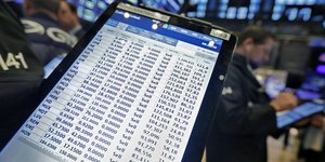 Την κίνηση των μετοχών στις αγορές παρακολουθεί επενδυτής μέσα από το κινητό του