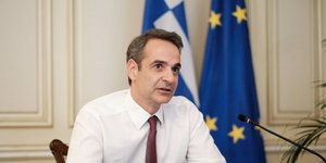 Ο Κυριάκος Μητσοτάκης μπροστά από σημαίες της Ελλάδας και της ΕΕ
