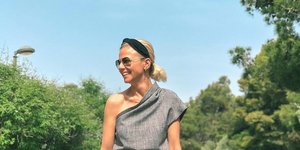 Η Χριστίνα Κοντοβά στην πόλη με γκρι ρούχα και σακίδιο