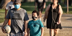 Κορωνοϊός οικογένεια με μάσκες στην παραλία