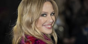 Η Κάιλι Μινόγκ χαμογελάει στον φακό φορώντας μοβ