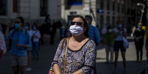 Γυναίκα με μάσκα για τον κορωνοϊό διαδηλώνει στην Ισπανία