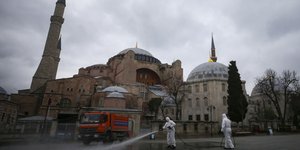 Άνδρες απολυμαίνουν τον χώρο έξω από τη Αγιά Σοφιά στην Κωνσταντινούπολη
