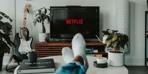 Τηλεόραση που έχει netflix και πόδια που φορούν λευκές κάλτσες