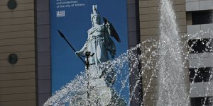 Το άγαλμα της Αθηνάς σε αφίσα στην πλατεία Ομονοίας. Σε πρώτο πλάνο το συντριβάνι