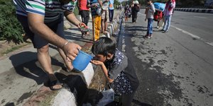 Ενήλικας δίνει νερό σε παιδί