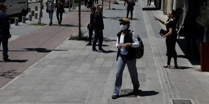 Γυναίκα με μάσκα περπατά στον δρόμο