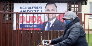 Ποδηλάτης περνά μπροστά από αφίσα του Ντούντα για τις εκλογές στην Πολωνία