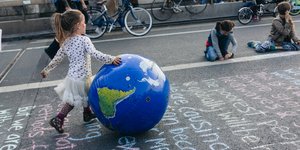 Κοριτσάκι με φουσκωτή μπάλα σε σχήμα Γης