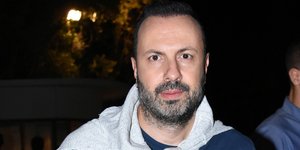 Ο Τάσος Τρύφωνος με μπλε μπλούζα και τζιν