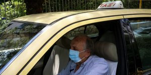 Οδηγός ταξί με μάσκα για τον κορωνοϊό