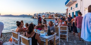 Τουρίστες σε υπαίθρια τραπέζια ταβέρνας στη Μύκονο