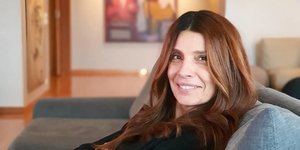 Η Πόπη Τσαπανίδου κάθεται στον καναπέ της