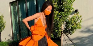 Η Vera Wang με πορτοκαλί φόρεμα και μαύρο σορτς