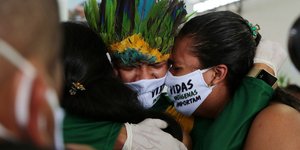 Βραζιλιάνοι με μάσκες για τον κορωνοϊό, κλαίνε αγκαλιά