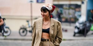 γυναίκα με μπαντάνα και σακάκι περπατά στη εβδομάδα μόδας