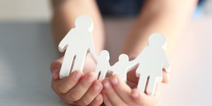 υιοθεσία παιδί κρατά ξυλινη οικογένεια