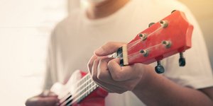 Άνδρας με μάσκα προστασίας από τον κορωνοϊό παίζει γιουκαλίλι