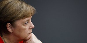 Η καγκελάριος Άνγκελα Μέρκελ σκεφτική, με κόκκινο ταγέρ