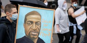 Διαδηλωτής με σκίτσο του Τζορτζ Φλόιντ